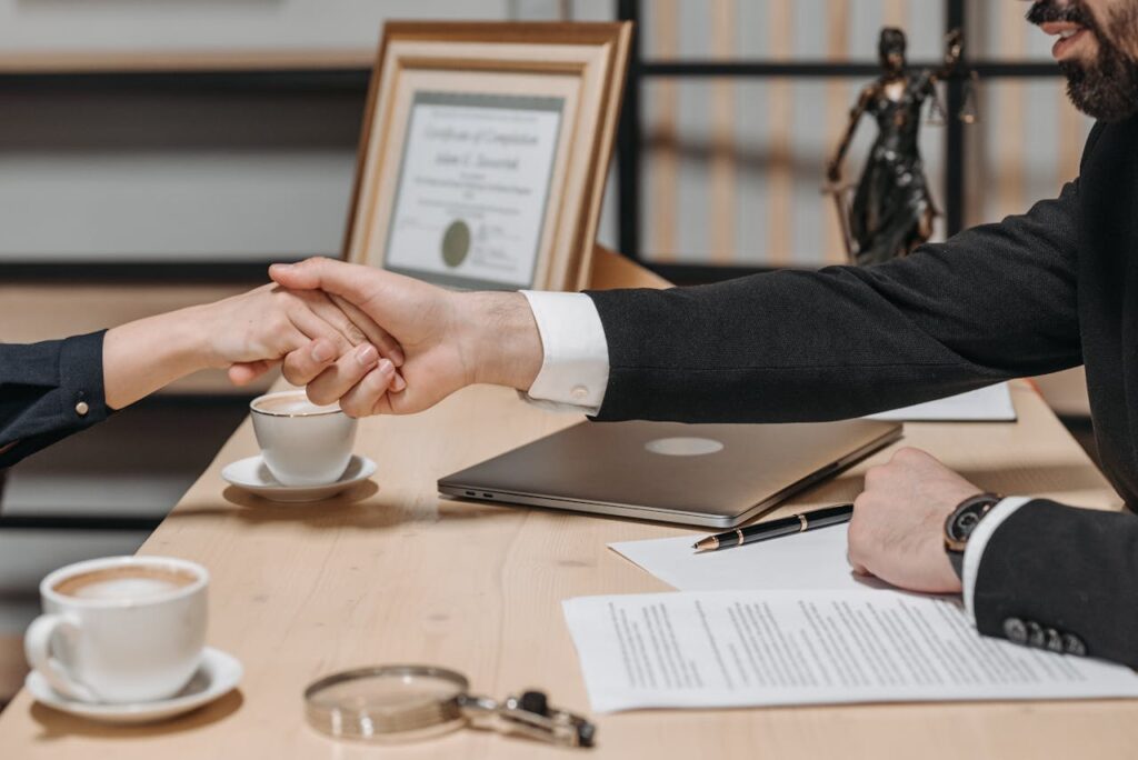 pexels-photo-8112180 A formal handshake over a business contract in a corporate office setting.