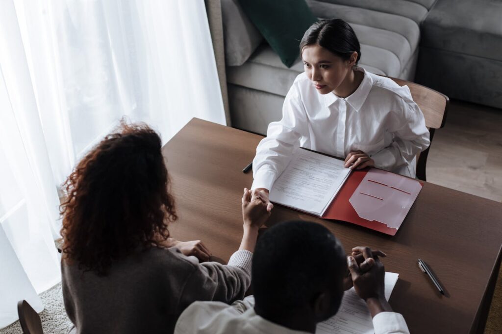 pexels-photo-9870153 High angle view of business meeting with diverse participants shaking hands over contract.